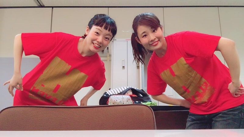 赤地のTシャツにゴールドプリントの2人